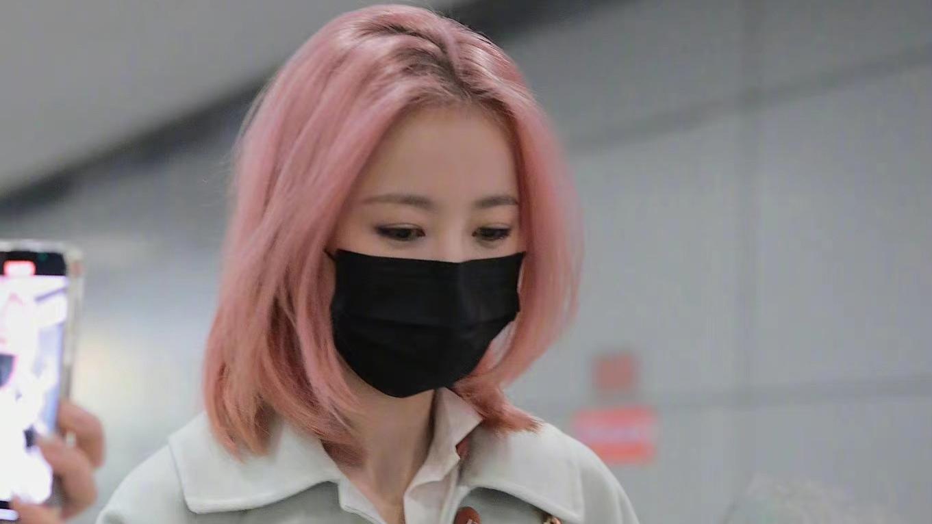 周雨彤染粉色头发走机场，搭配米白色大衣，个性洋气又时髦！