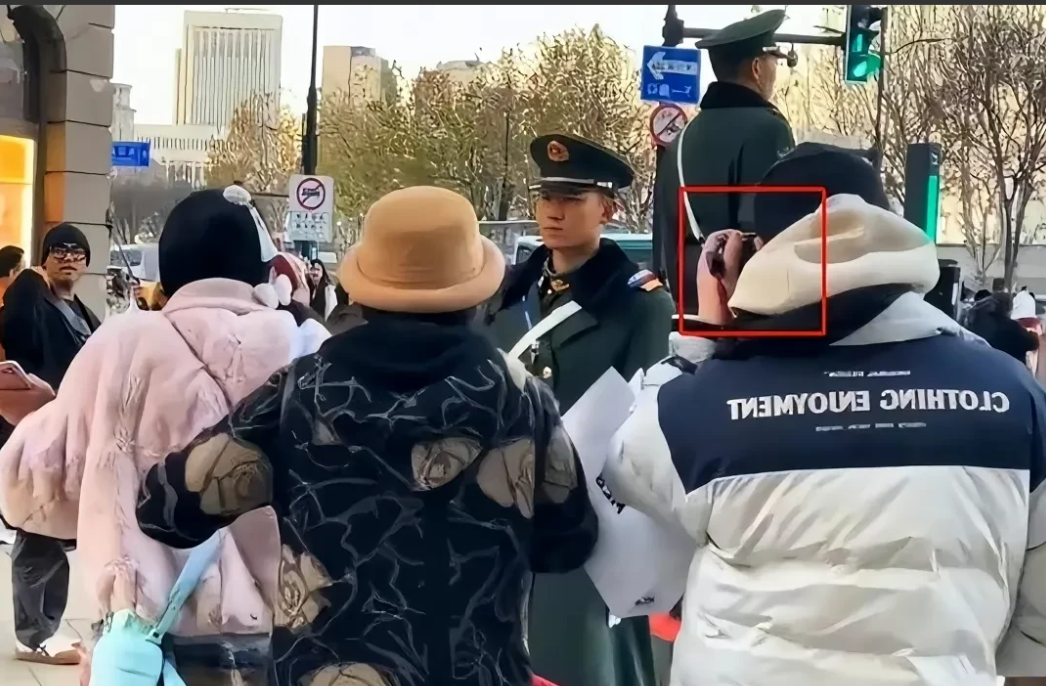 上海南京步行街女子骚扰怼站岗哨兵这事儿不对劲儿。
疑似现场有黑衣人招手打手势，有