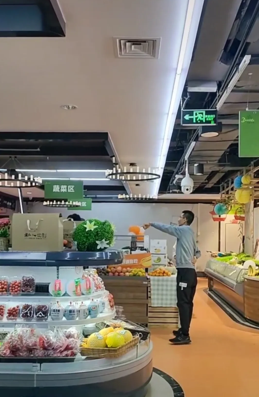 孙东旭在东方甄选后台休息，可以看到架子上琳琅满目摆放了很多商品，分为了蔬菜区、水