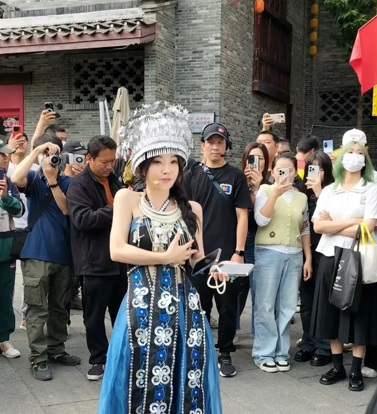冯提莫现身南宁街头直播。 个子矮小的他戴着苗族头饰，显得自信，身子更小。 她变得