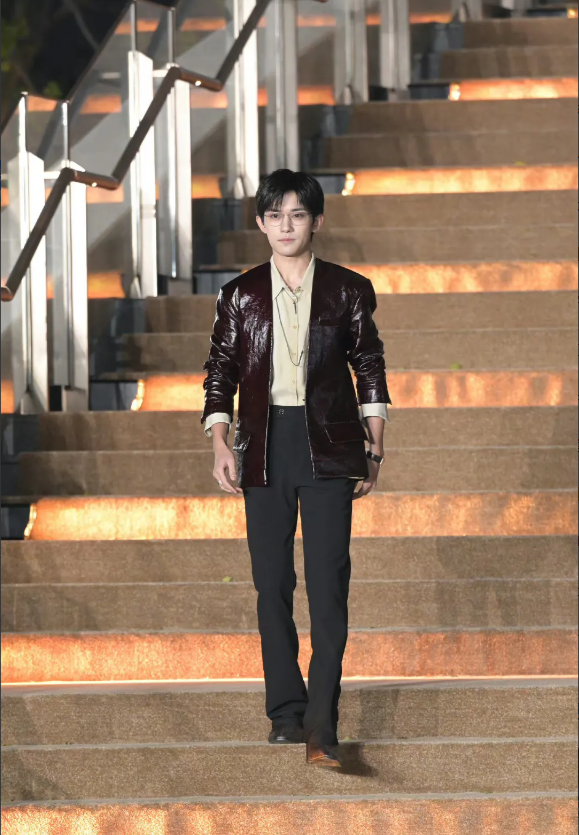 天啊，这身打扮好土啊，本来个子就不高，还穿一身长皮衣，还配一条黑色腕带的表，好像