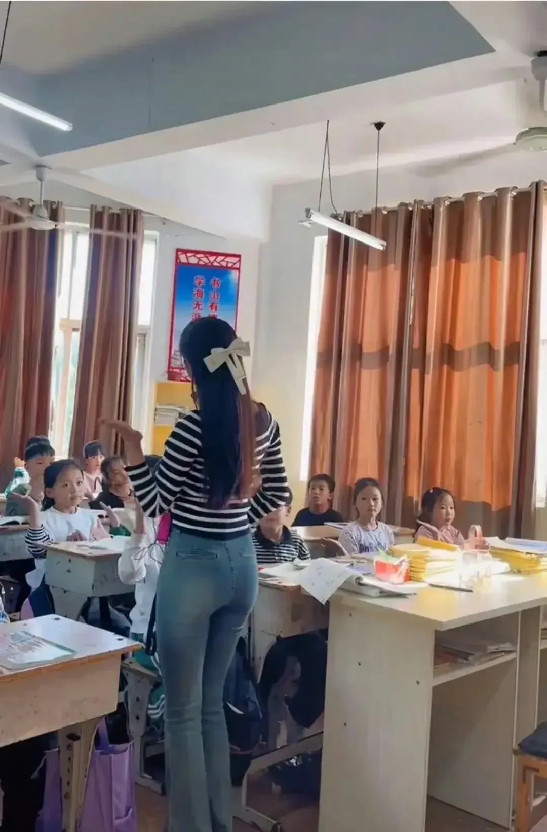 河南一位小学女老师上课视频在网上火了。有网友质疑她的穿着，不适合教书育人。对此你