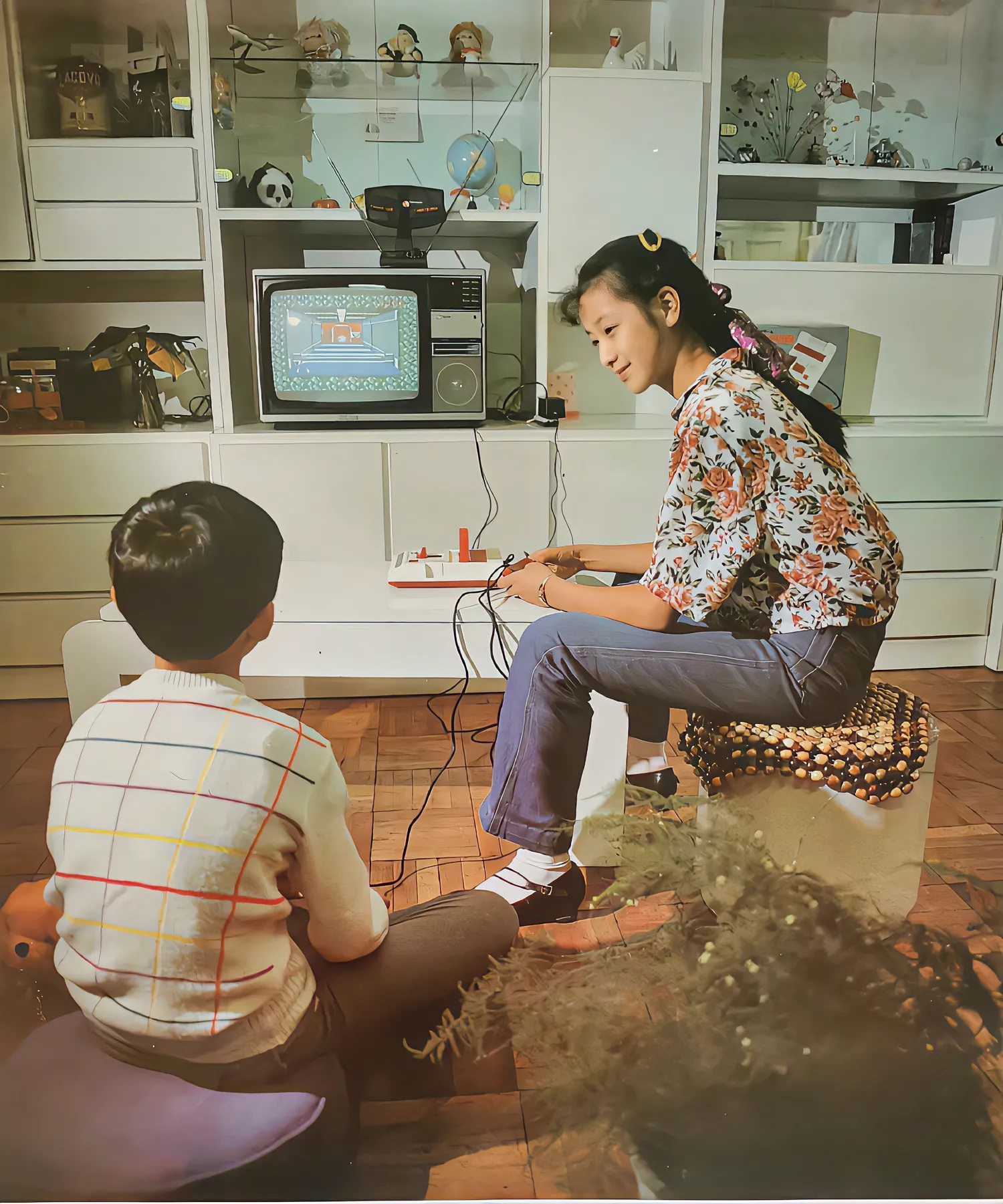 1991年，年轻的母亲陪着儿子玩任天堂红白游戏机，没看出玩的什么游戏