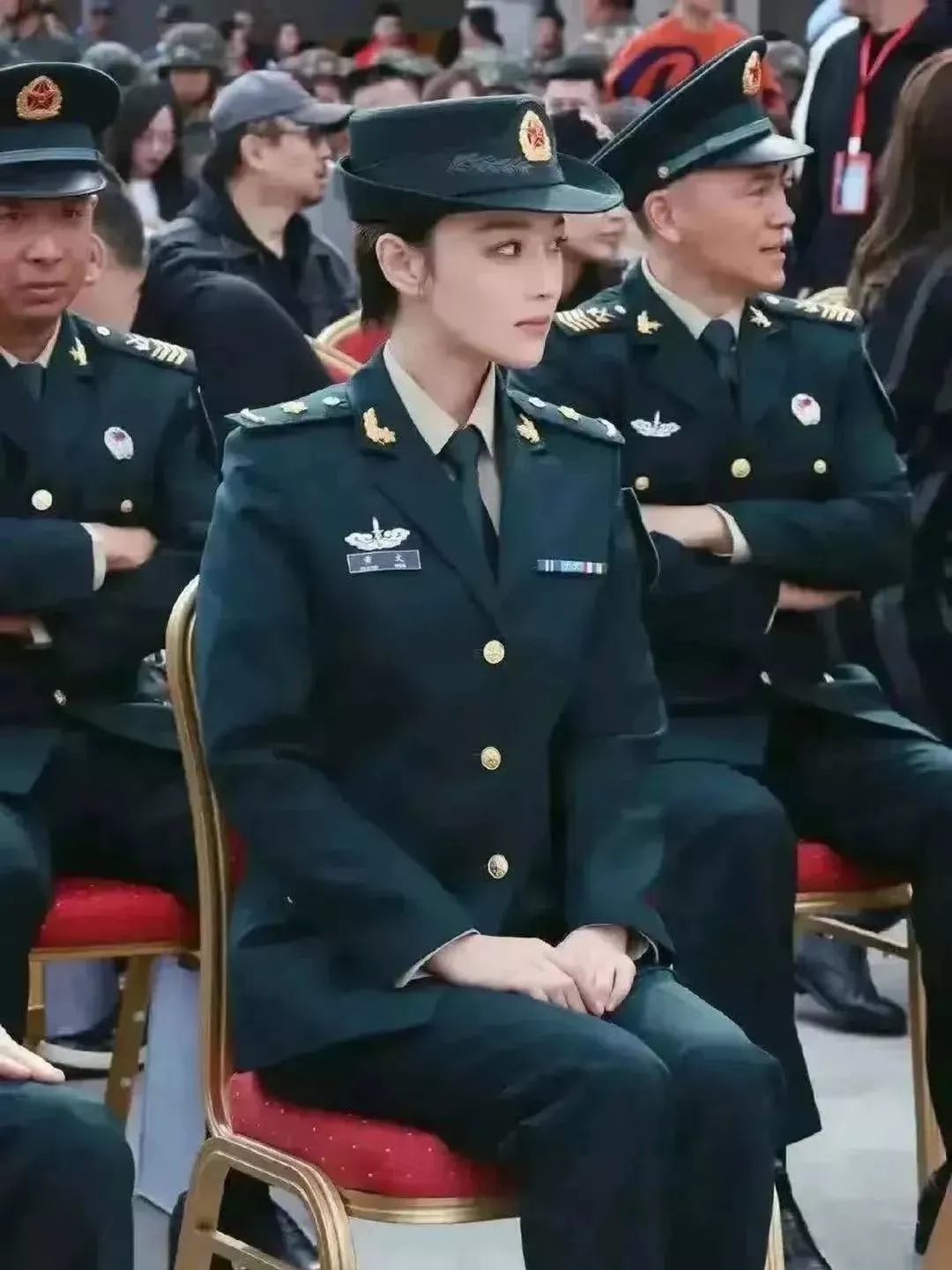 这张照片的焦点不是坐在前排的漂亮军官。 虽然她美丽出众，气质优雅，但她只是一名文