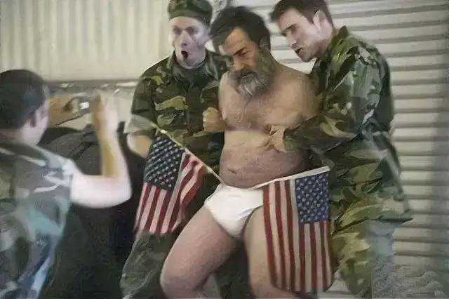 2006年，萨达姆临刑前被脱去衣服，两位美国士兵架着着他，内裤上插两面美国国旗，
