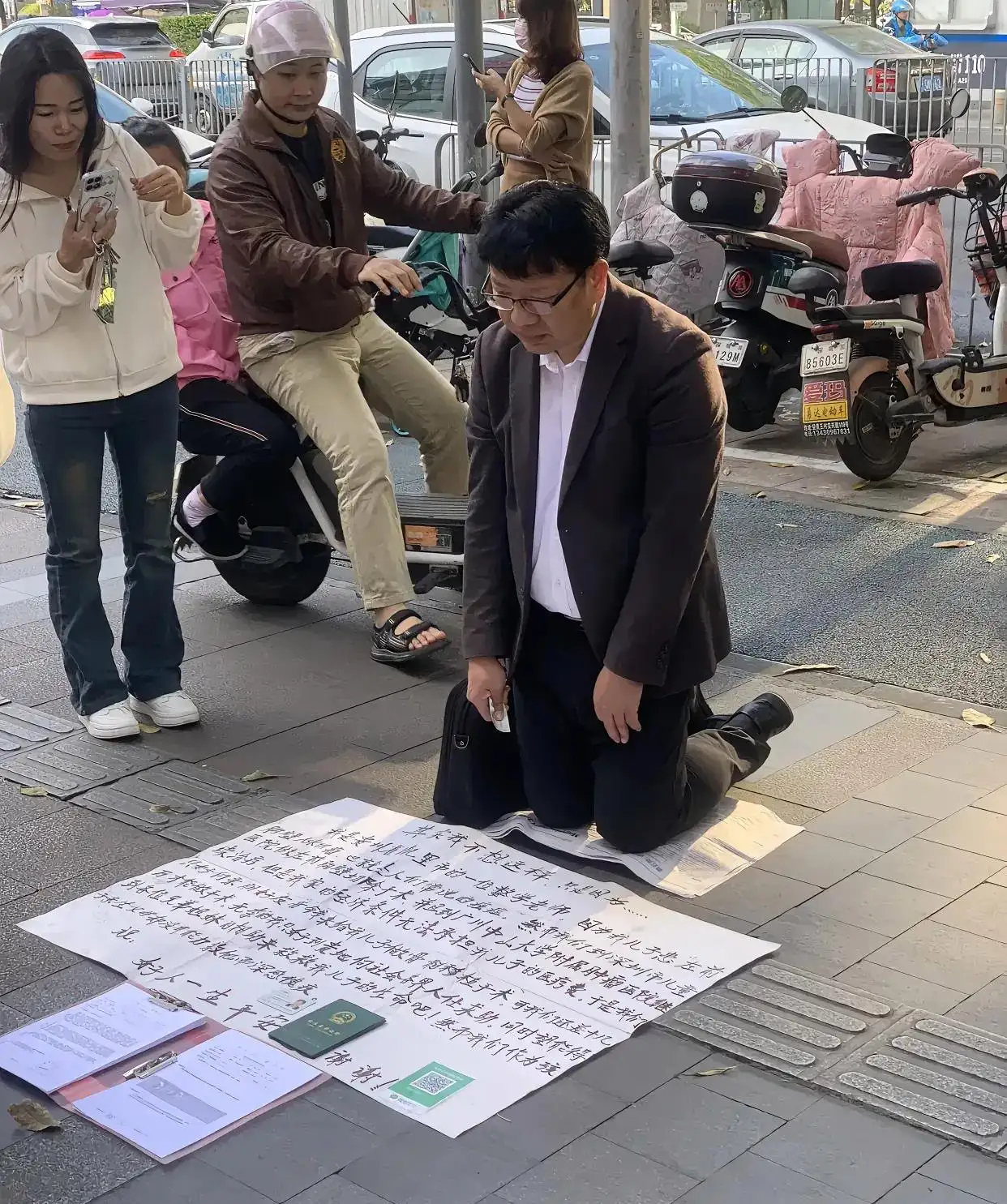 深圳街头一位中年数学老师跪地乞讨，称其儿子重病急需用钱，无奈请求社会好心人扫码“