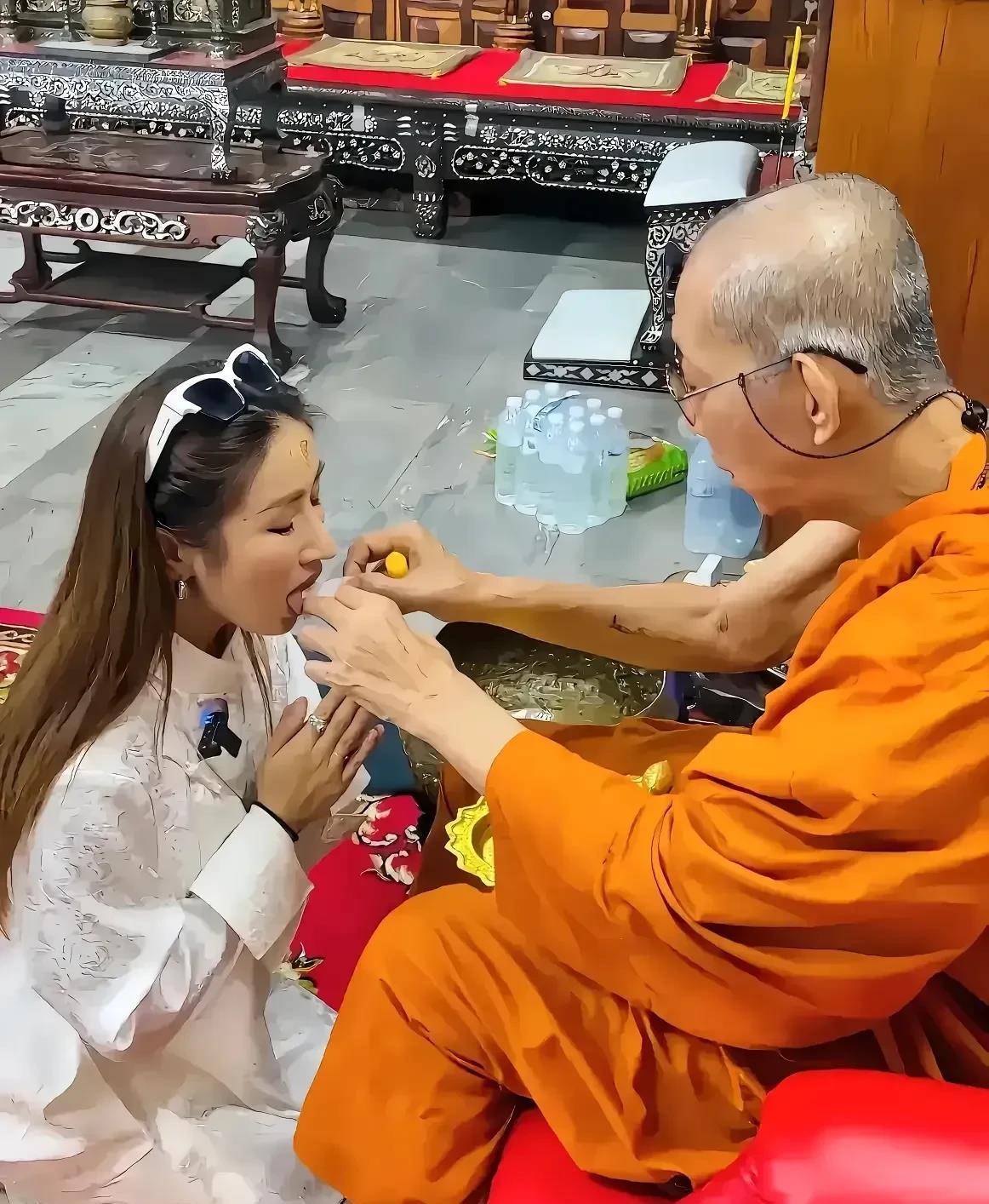 照片中这位大师正在干什么呢，是在给这位年轻的女士开光还是治病啊？
大师坐在一把红