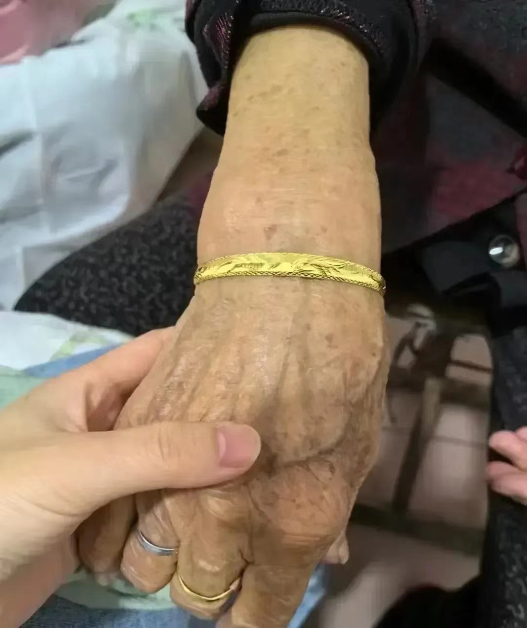 在老家，一位年逾八十的老人离世了。在为她更换寿衣时，她的子女细心地将她手上的金镯