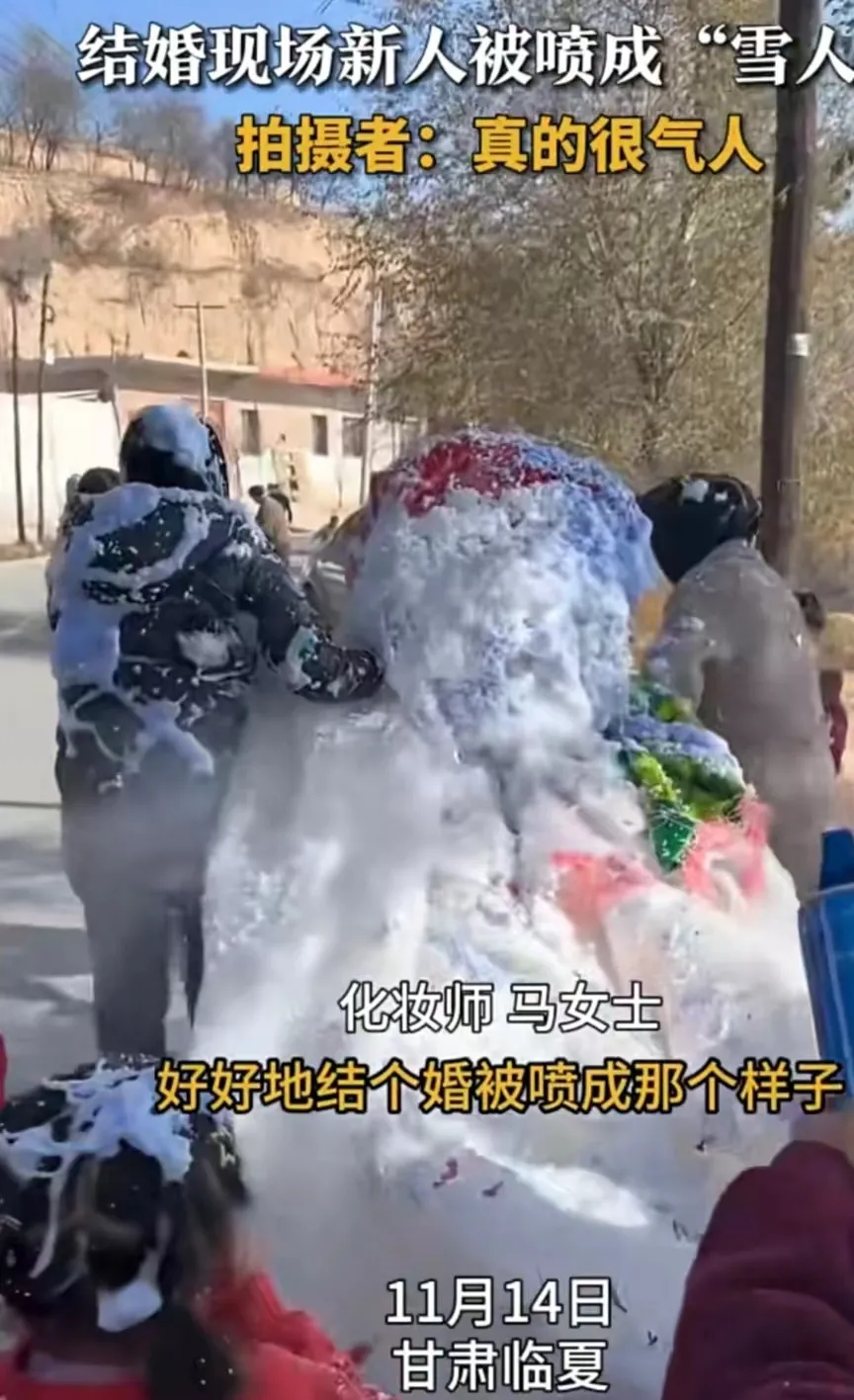 甘肃。一对新人在结婚的时候，新娘穿着洁白的婚纱，刚一下车，就被新郎家的朋友喷成了