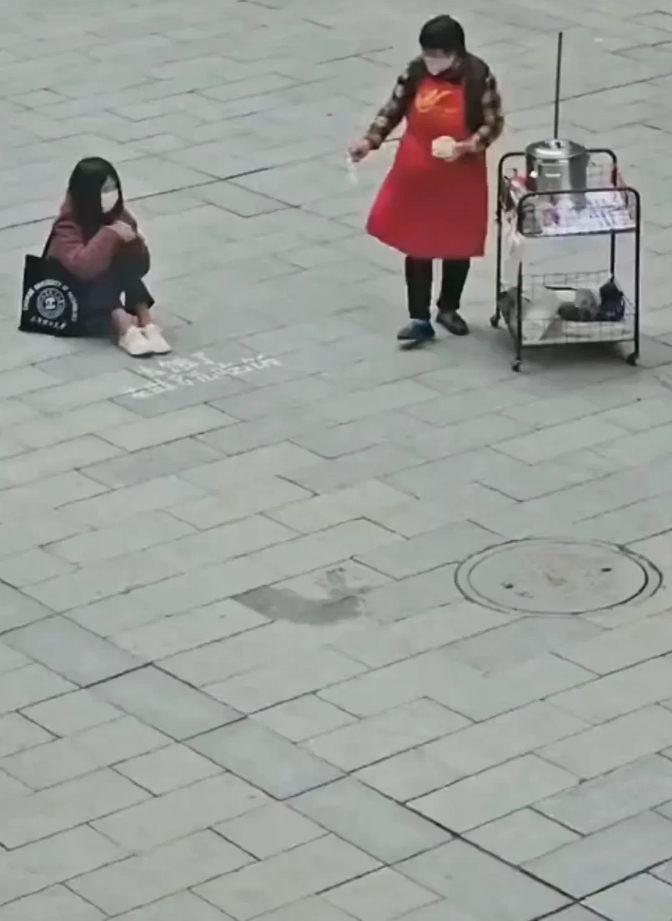 
女子卖身不卖艺，讨钱不讨饭😀
画面中，一位好心的阿姨拿了一碗粥给坐在地上的女