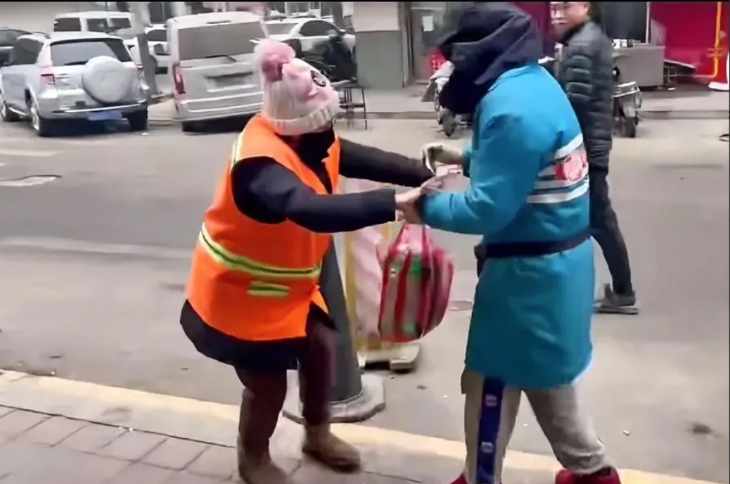 环卫工阿姨正在清扫一家店铺门前的垃圾，店老板却突然跑过去，一把拉住了环卫工阿姨…