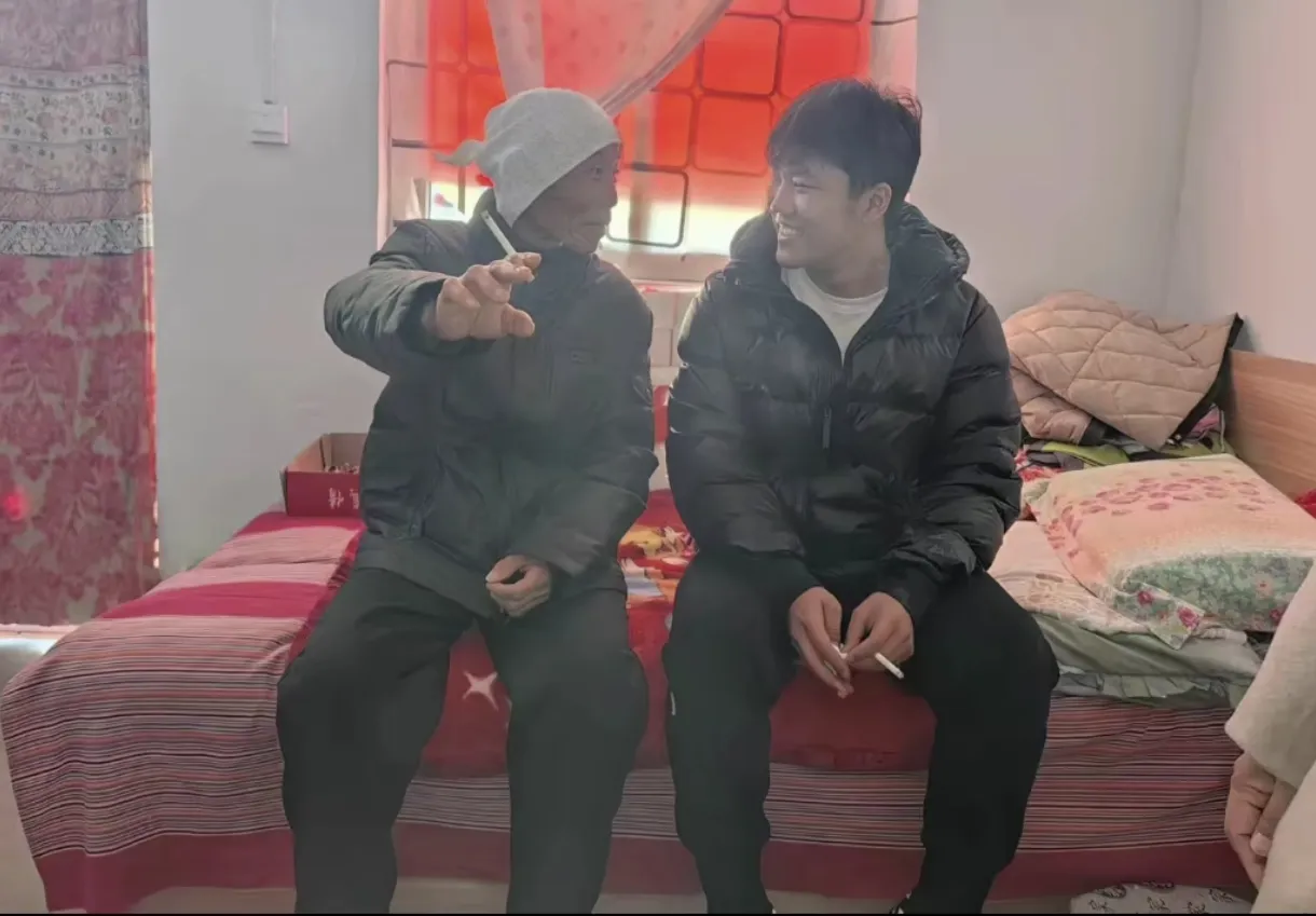 一张等待26年的合影见证了爷孙情深。照片中的解清帅坐在简朴的炕头，陪爷爷抽烟聊天