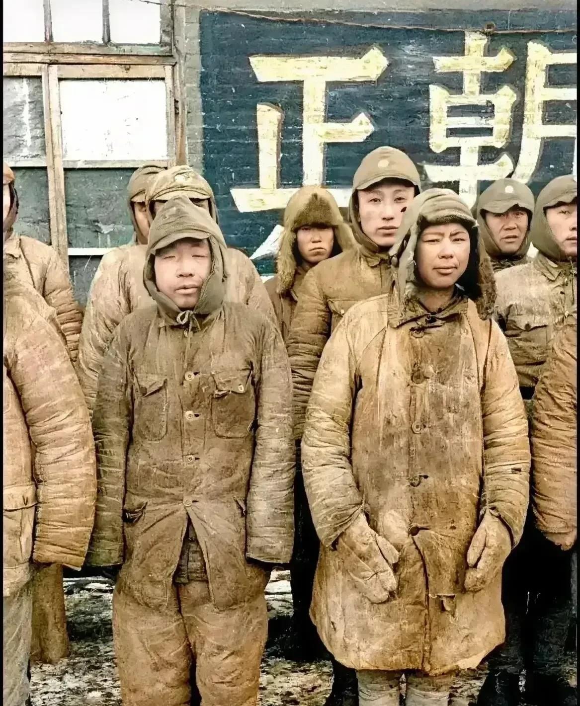 这是1948年一群投降了的国军士兵，站在墙角的照片。他们站成三排，在冷风的吹拂下