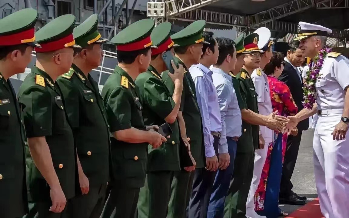 美国航母里根号访问越南，越南军官在迎接客人的时候，有两位军官其中一人正在打电话，