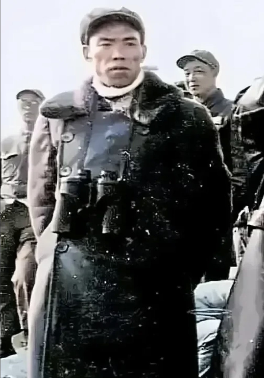 在朝鲜战场的冰雪严寒中，万岁军军长梁兴初如一位铁血战神傲立风雪之中。他身着一袭厚