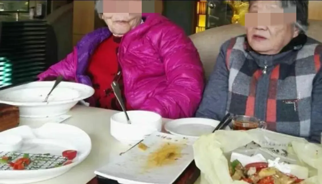 山东，三位年逾八旬的老奶奶正在享用一顿丰盛的午餐。她们自带着一瓶珍藏已久的白酒，