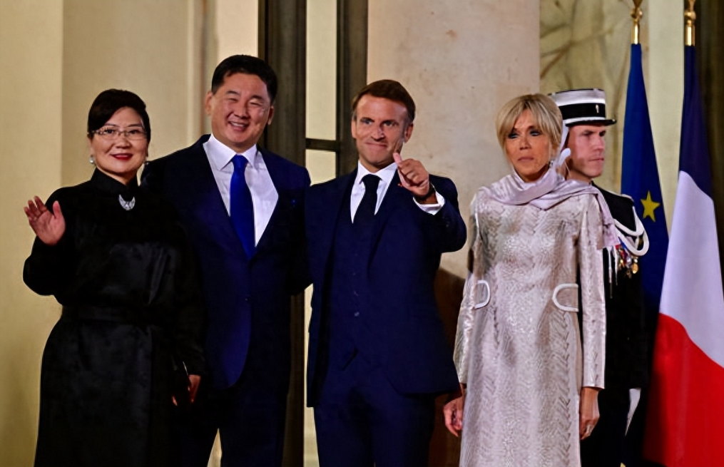 70岁法国第一夫人接待蒙古国第一夫人，穿紫色时装裙系着配套围巾，一身时髦打扮脚踩