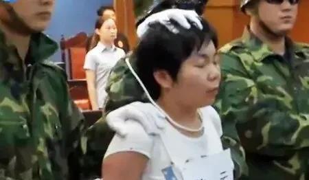这是2014年，在济南，犯罪嫌疑人姜云被安置上绞刑绳索，她的脖子上额外绑着一根绳