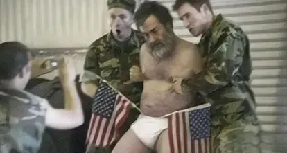 2006年，萨达姆临刑前被脱去衣服，两位美国士兵架着着他，内裤上插两面美国国旗，