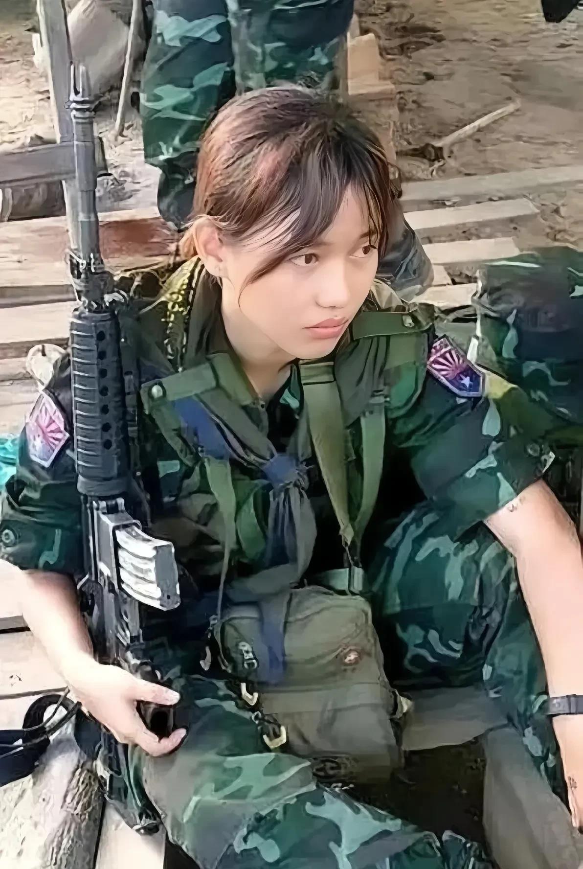 这是缅甸果敢联军的一名士兵。它看起来非常漂亮。
照片中，她坐在地上，全副武装，手