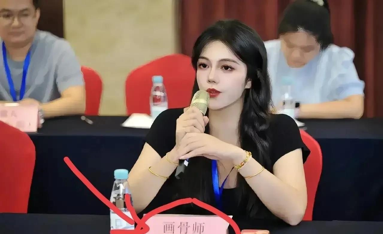 一个年轻的女子，正在参加一个会议，这一幕被摄像师抓拍到，她的面前摆了一个牌子，引
