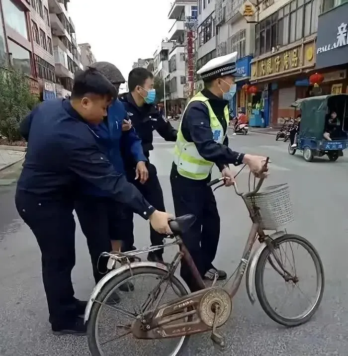 这张照片拍摄于2023年，上海退休法学教授李自忠骑自行车接孙女上放学时，被交警以
