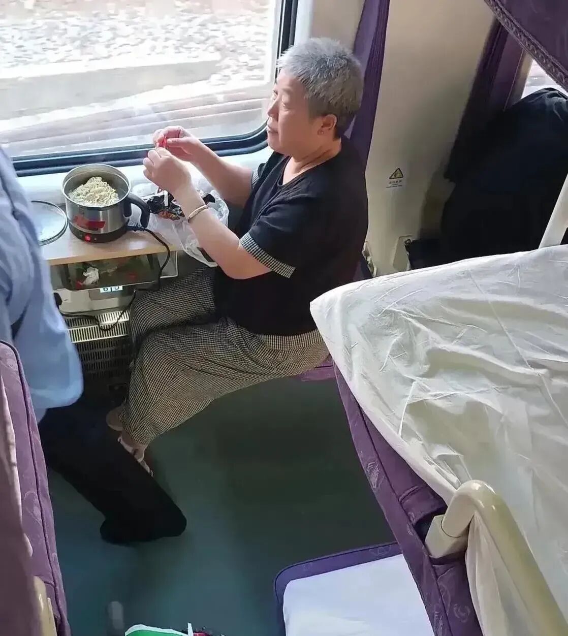 有位大妈在高铁上吃不起48元一份的盒饭，但她很聪明，带了一个电热锅，可以随时煮面