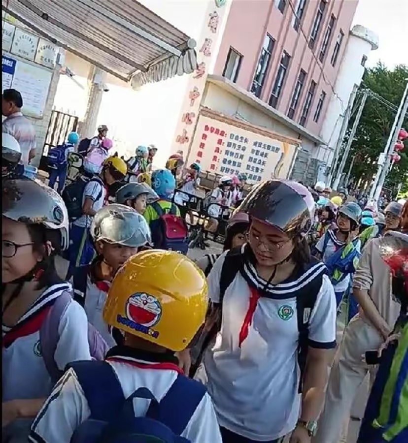 壮观啊，小学生戴头盔进校园，很多家长表示不解，头盔成了上学标配，是不是意味着书包