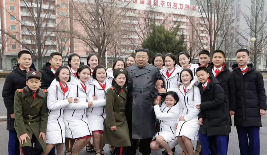 朝鲜的孩子们看到最高领导人，不由得略蹲下来，以突出慈父的高大形象。