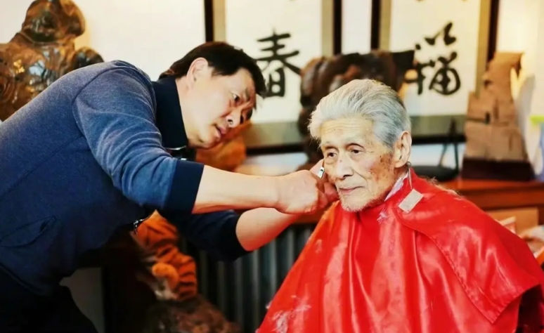 2022年，69岁的濮存昕为95岁的“恩师”蓝天野老先生剪发，濮存昕非常的专注和