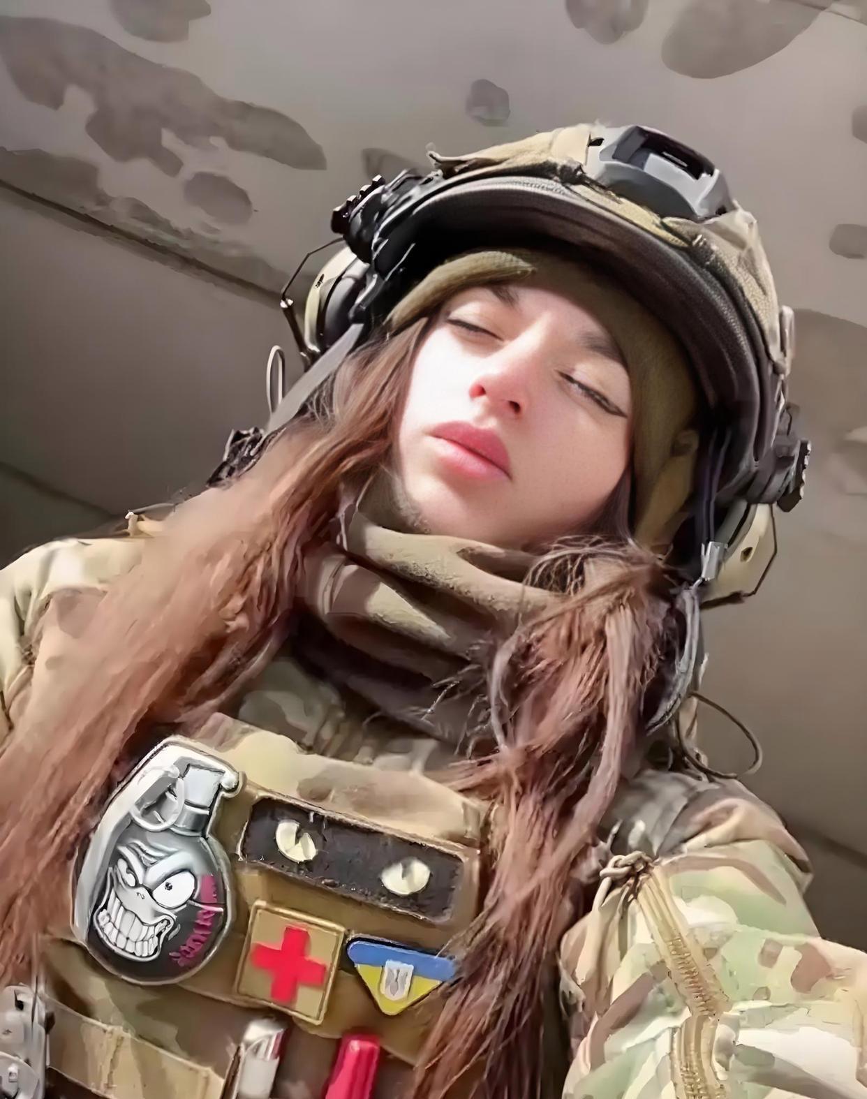 一位乌克兰女兵，身体被炸成两截，躺在荒草地里。一个即将撤离的男兵于心不忍，在她的