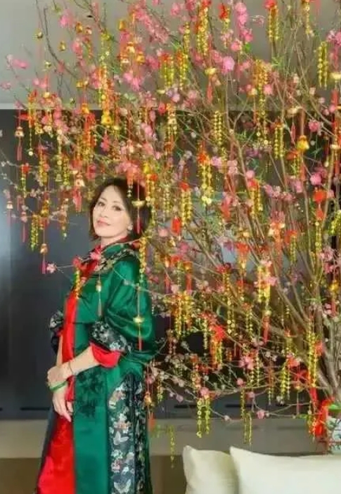 刘嘉玲身着中式红配绿新年装，大胆配色被她完美驾驭，复古韵味尽显。她状态极佳，岁月