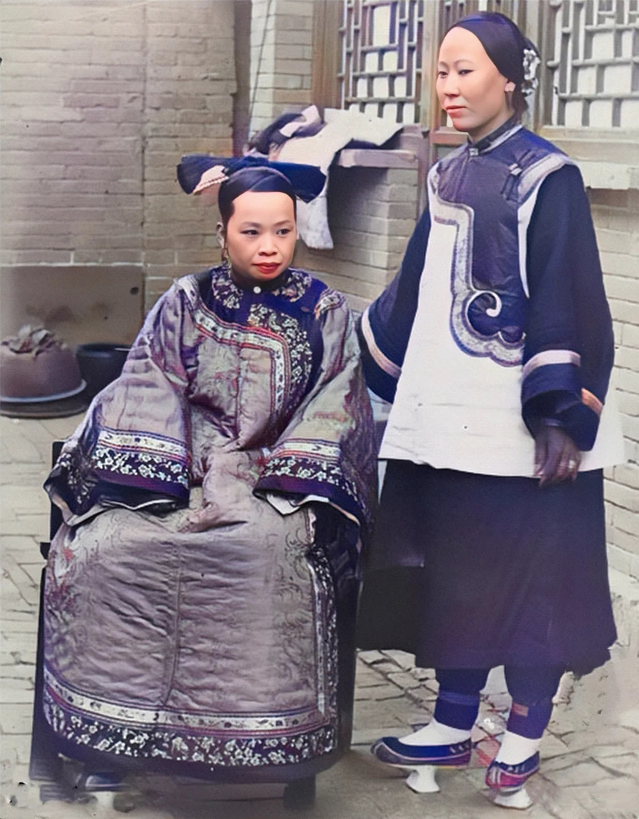 1903年，一位旗人家的贵妇人与贴身仆人的罕见留影。镜头下的贵妇身穿精致裁剪的长