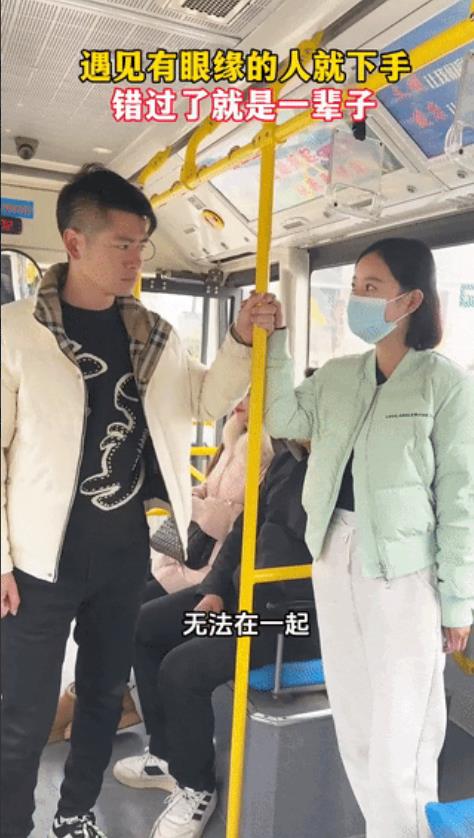 公交车上，一年轻女孩站在车厢中间，手扶着安全杆，在她旁边的一名男子，也一手扶着安