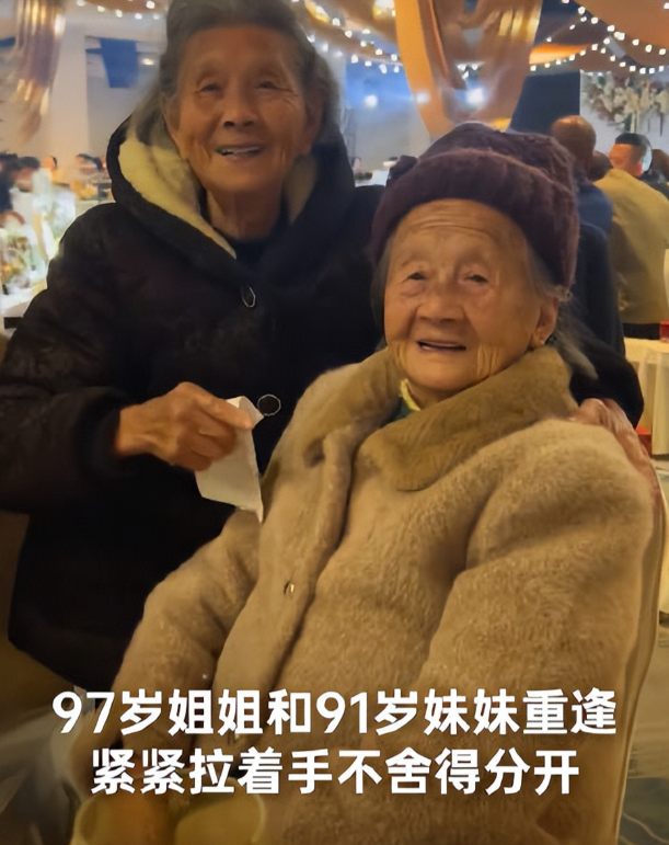 11月26日，97岁姐姐和93岁妹妹好久不见，却在孙女的婚宴上重逢！两人紧握着双