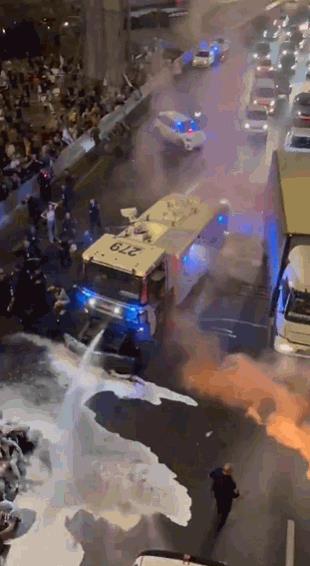 在不久前的以色列国内示威游行上，警方用水枪喷洒静坐在一起的示威人群，但是喷出的带