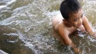 一小孩被水流冲走，突然水中游来一条蟒蛇，蛇不仅没攻击，还让小孩抱着它游上岸