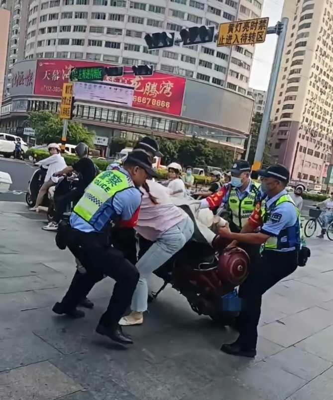 “我配合，不要动我了！”海南海口，一女子骑电动车时，被4位交警团团围住，而后一人