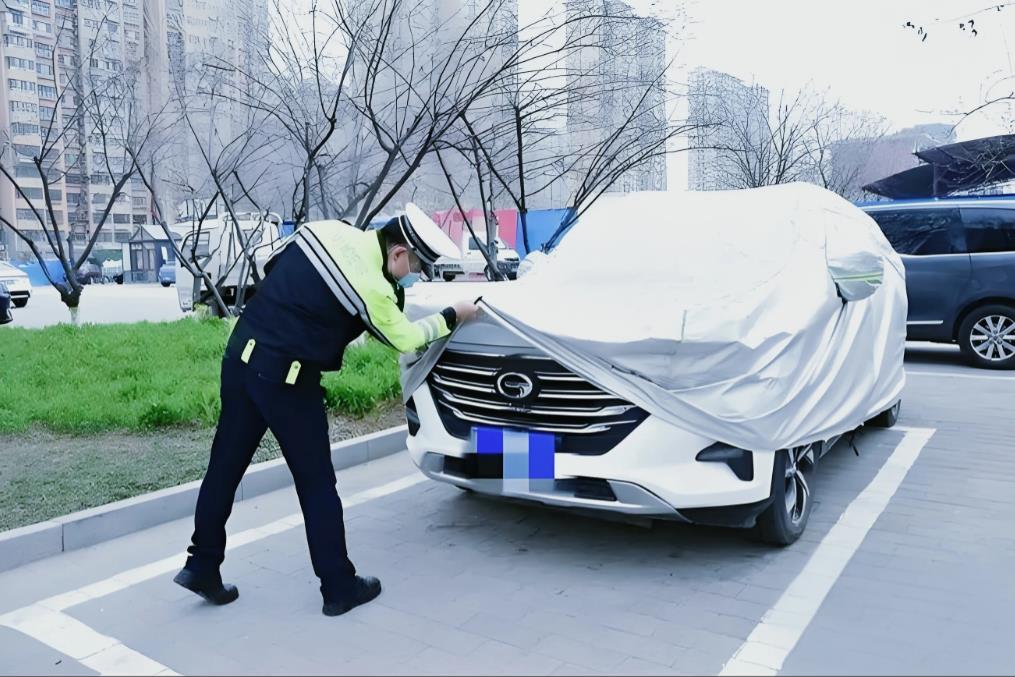 北京，一男子把车停在路边，怕狗狗在他车轱辘上撒尿，他给爱车罩上车衣，万万没想到，