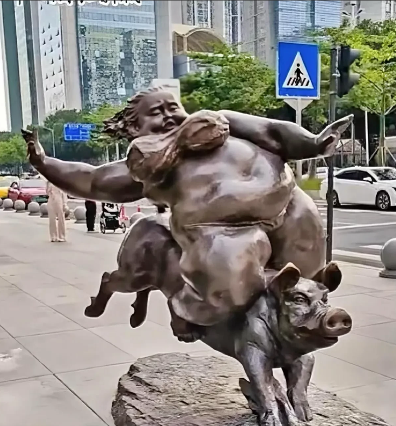 今天又被街头的一尊雕塑雷到了，是一个硕壮的女人骑着一头猪在狂奔，猪是奋力想甩下女
