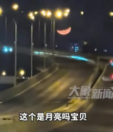 北京一女子开车上高架时，看见月亮特别的低，还又大又亮。女子本以为是假的月亮，想着