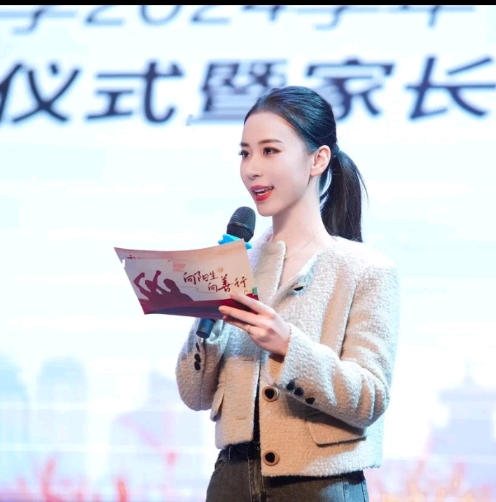 这位女士参加家长会，荣当家长代表。看她在发言台上风姿绰约，亭亭玉立，好像是在发言