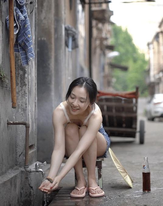 吴倩夏日清凉性感写真，条纹背心、牛仔短裤、粉色人字拖，再加上偶尔的湿身、光着的脚