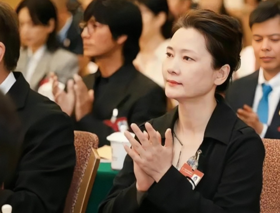 何赛飞在出席活动时的素颜照。镜头下的她头发盘起，身着简单黑色风衣，干练不失时尚，