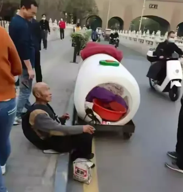 太不容易了！有一位流浪大爷，用塑料桶制造了一辆“房车”，并且在车子下方安装了四个