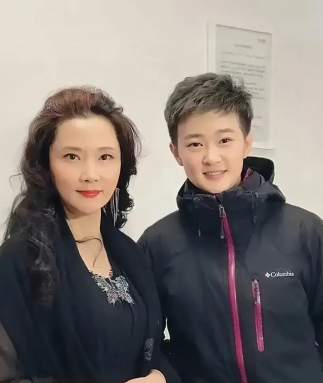 著名表演艺术家何赛飞与她心爱的儿子拍摄的温馨合照。镜头下的何赛飞穿着黑色的衣服，