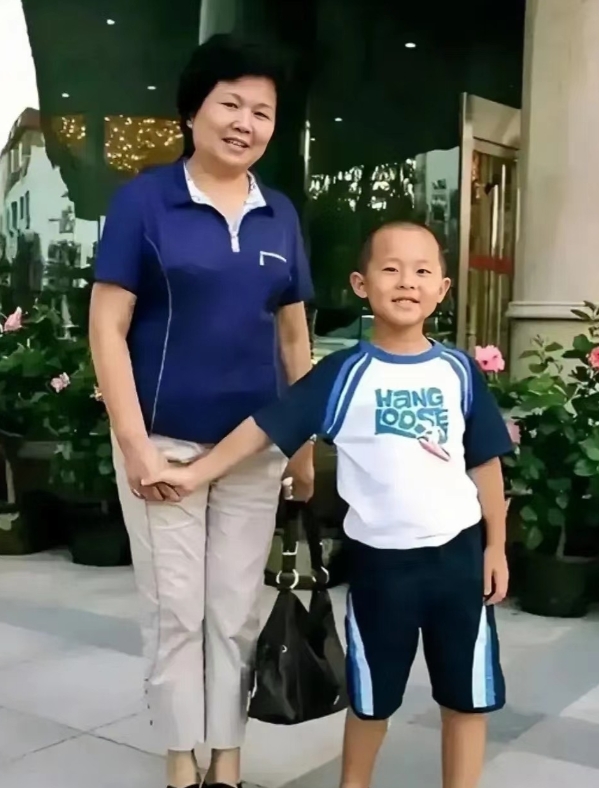 晚年的邢质斌和孙子的罕见合影。镜头下的她上穿蓝色上衣搭配休闲裤，一手提着包，一手