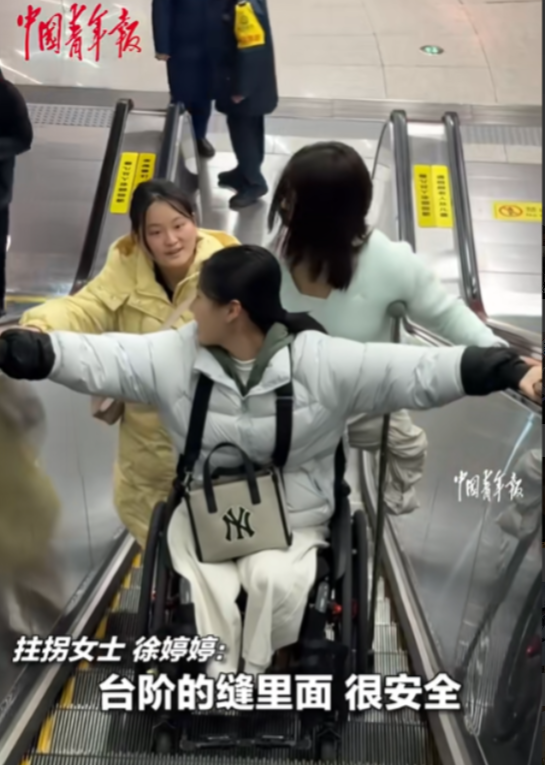 暖心！地铁站扶梯上，黄衣女孩见前面两位残疾运动员行动不便，担心他们摔倒主动伸手保