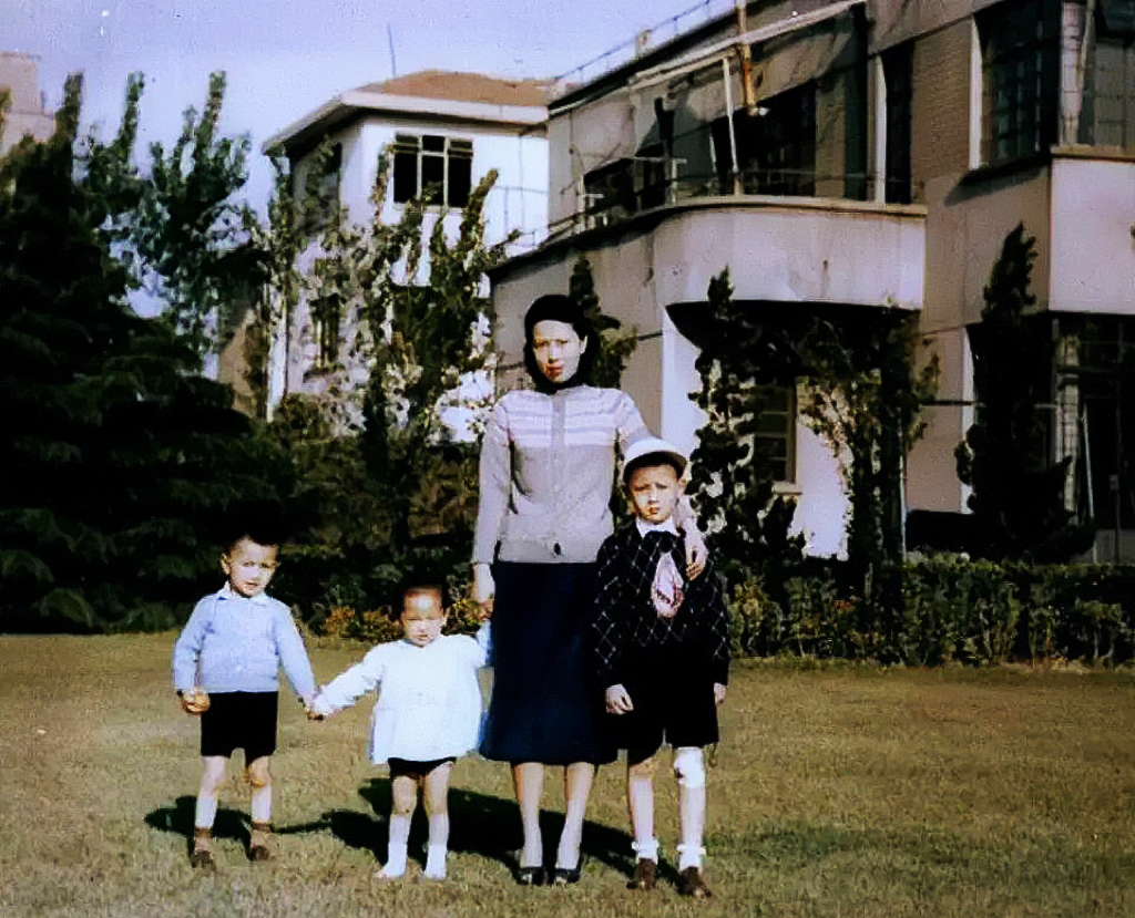 1950年5月，上海虹口区，一位母亲和三个孩子的合影。镜头下的他们正处于自家的院
