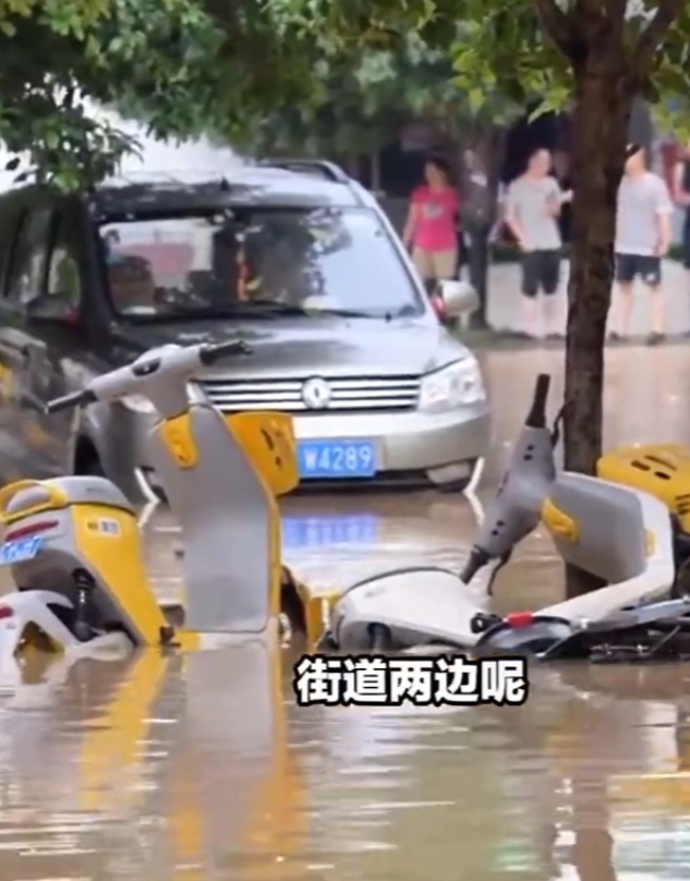 南方暴雨，广西桂林，满城的电动车被洪水冲倒，街道两边随处可见被堆放的小黄车。因为